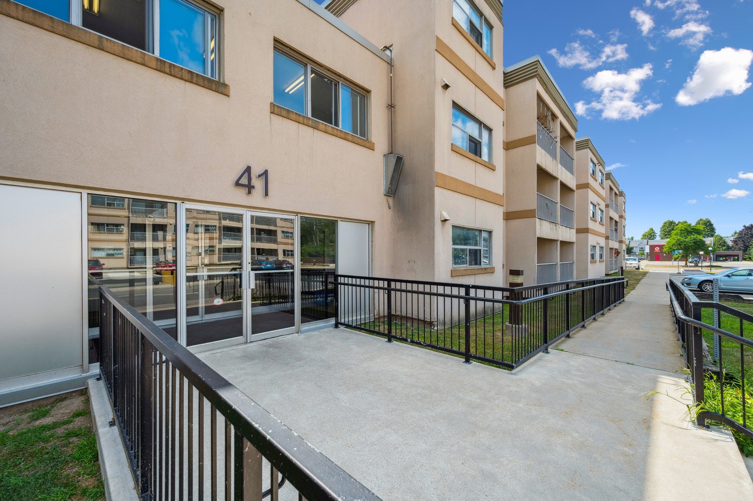 Apartment building number 41 with a black railing and a concrete walkway.